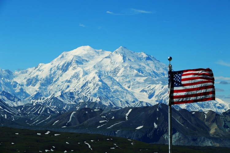 US flag with snowy mountain in background