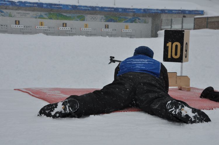 new sports to try: man in biathlon event shooting rifle