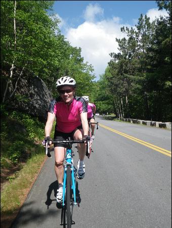 person cycling on roadway in Acadia National Park