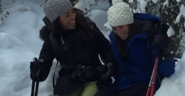 two females laughing while snowshoeing