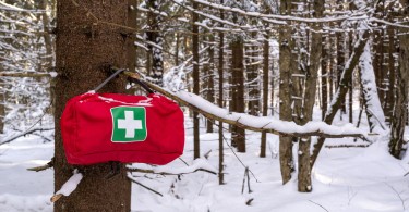 first aid kit hanging on tree with snow