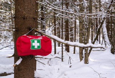 first aid kit hanging on tree with snow