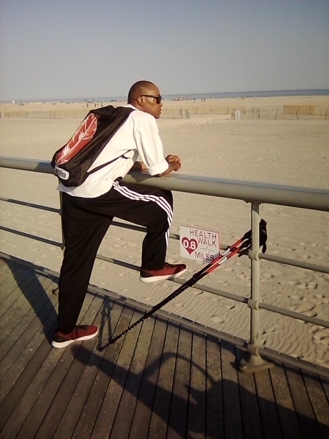 man on boardwalk looking at beach