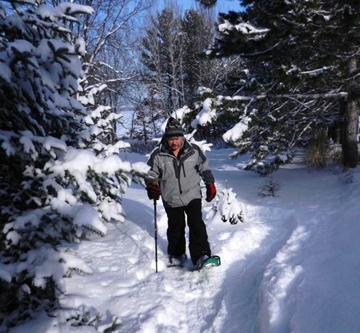 man snowshoeing with one hiking staff