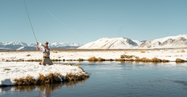 man fishing in winter with snow on ground