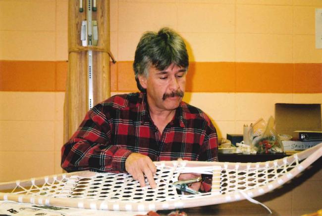 man looking at Obijwe snowshoes on a table