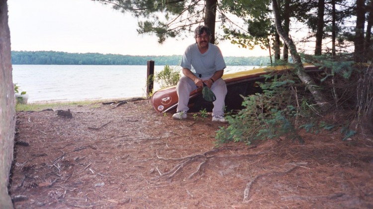 man resting on a canoe near lake in Sylvania Wilderness