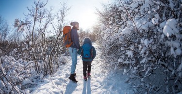 mom and child on winter hike in snow