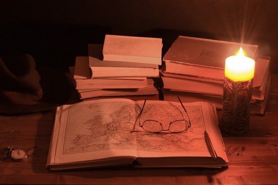 treasure map next to a candle and other books