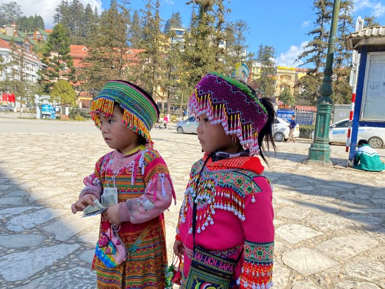 girls dressed in traditional colorful clothing in city center
