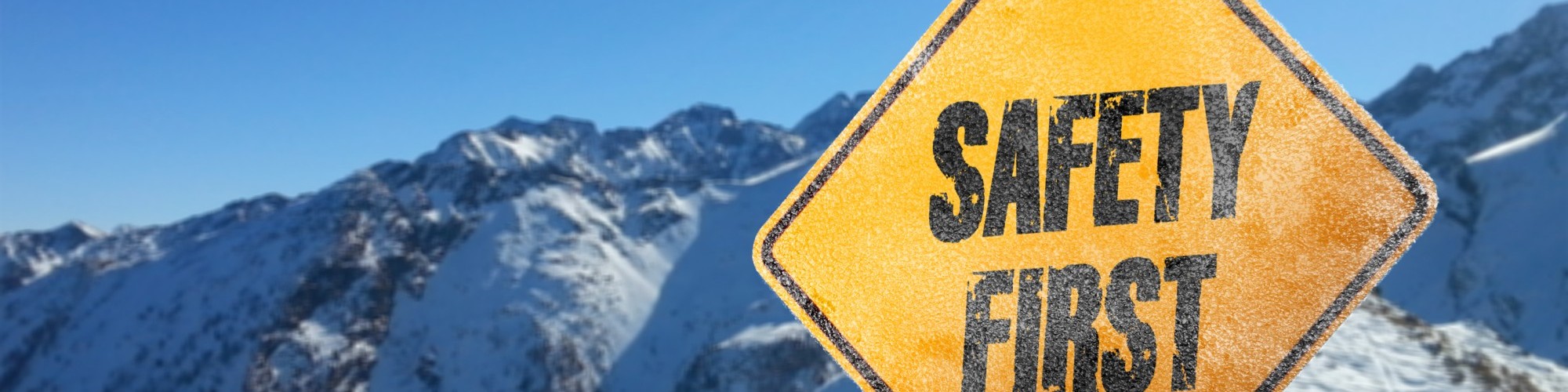 yellow safety sign in mountains surrounded by snow