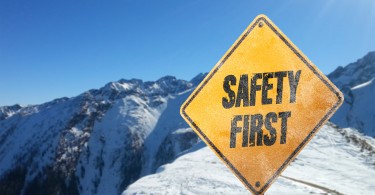 yellow safety sign in mountains surrounded by snow
