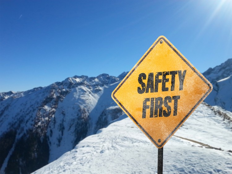 snowshoeing safety: yellow safety sign in mountains surrounded by snow