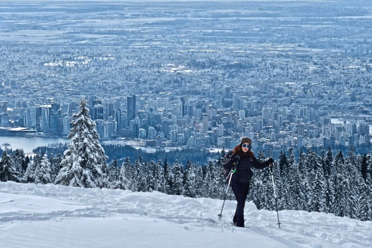 snowshoer on Cypress Mountain with view of Vancouver in background