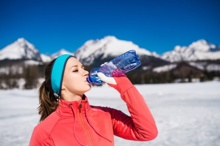 snowshoeing recovery: woman in winter with water bottle