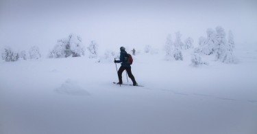 person snowshoeing with poles in snowy conditions