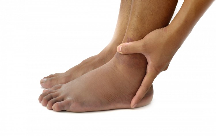 person holding ankle on white background