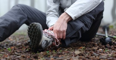 close up of person holding ankle on the trail