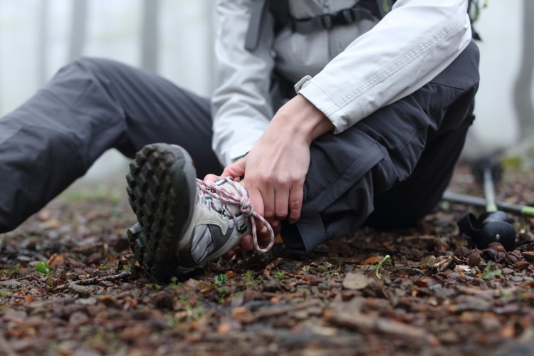 close up of person holding ankle on the trail