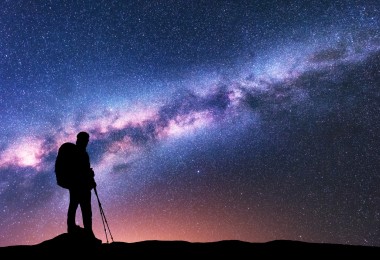 man silhouette in front of starry multi-colored sky