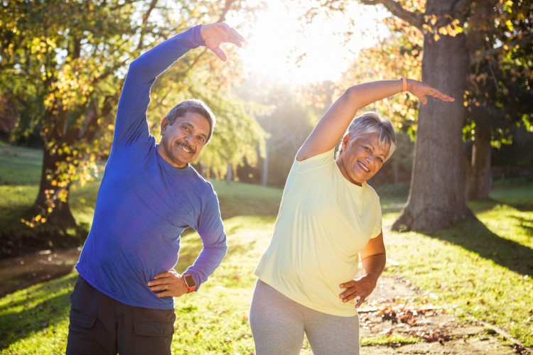 mature couple stretching outdoors in warm and sunny weather