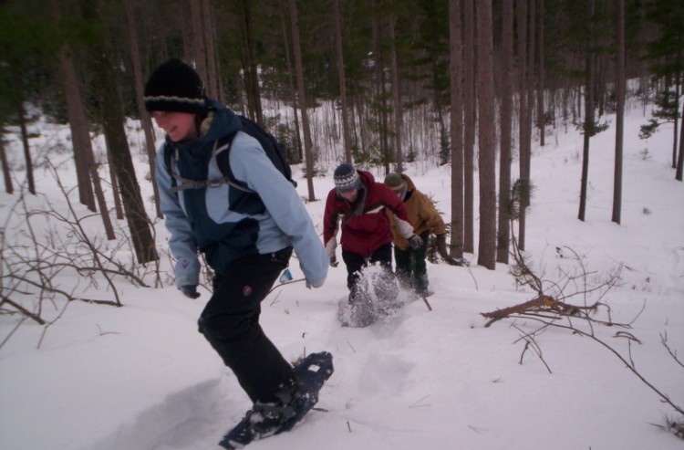 snowshoeing health benefits: students going up hill in snowshoes