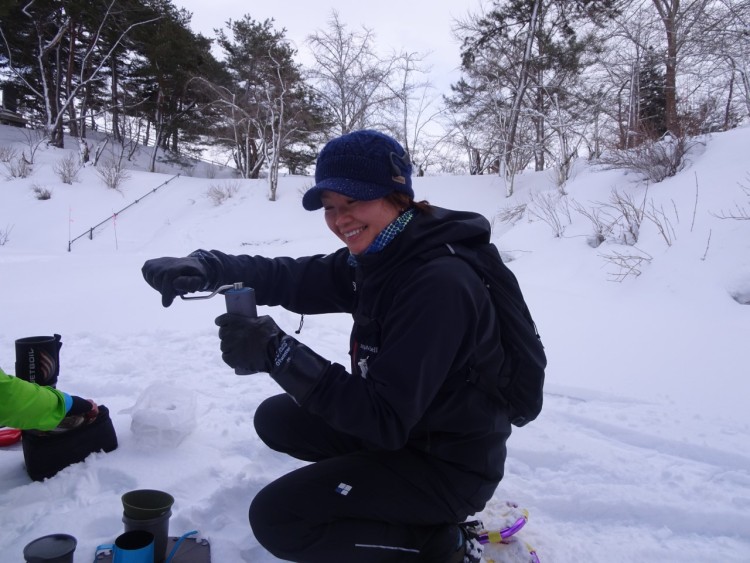 person grinding coffee in the snow