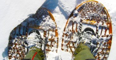 looking down at traditional wooden snowshoes with boots