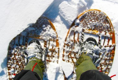 looking down at traditional wooden snowshoes with boots