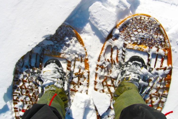 looking down at traditional wooden snowshoes with boots