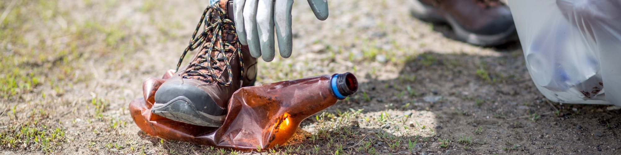 woman reaching down to clean up trash
