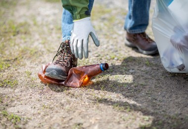 woman reaching down to clean up trash