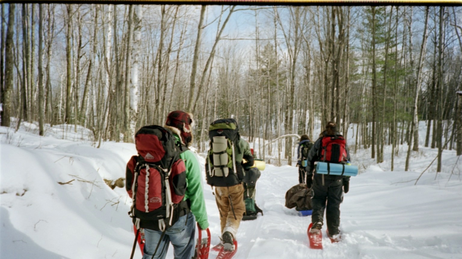students snowshoeing on winter trail