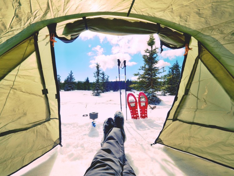 view outside of tent with snowshoes and blue sky in background