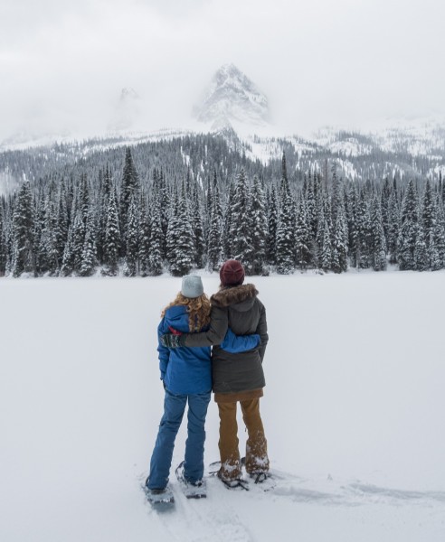 two people hugging on snowshoes looking at scenery, Island Lake Lodge